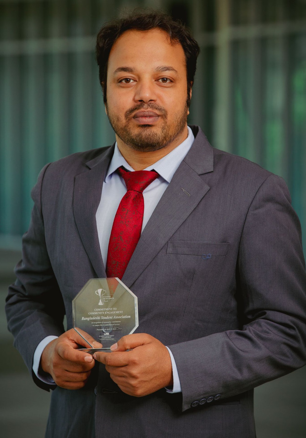 Md Akkas Ali holding the UAB Commitment to Community Engagement Award